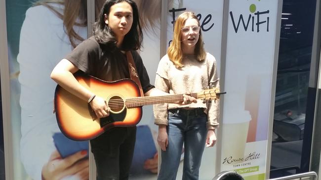 Kai Lao and Freyja Hewitson, from Kellyville High School, busking at Rouse Hill Town Centre. Picture: Lawrence Machado