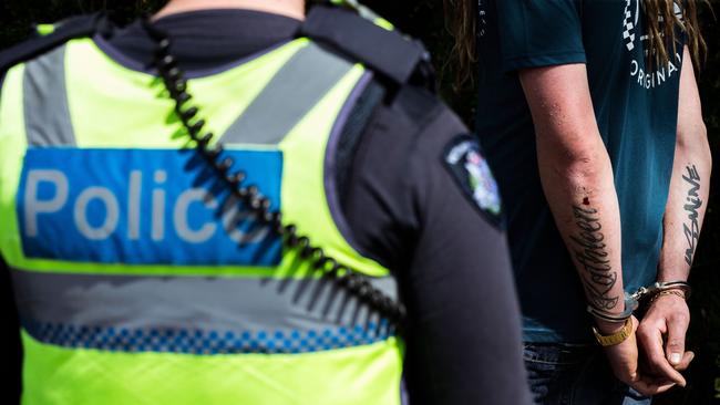 A man is detained by members of Victoria Police on Marine Parade in Brighton. Picture: Getty Images