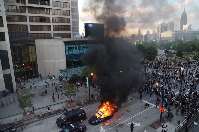 A police car burns after protesters marched to the Georgia State Capitol in Atlanta. Picture: AP