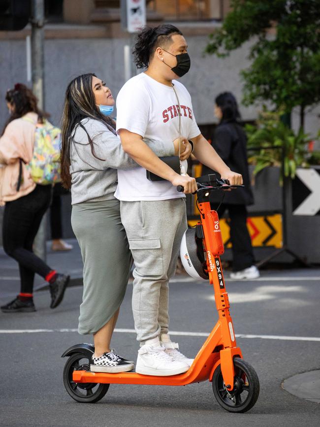 Two people ride a e-scooters in the CBD. Picture: Mark Stewart