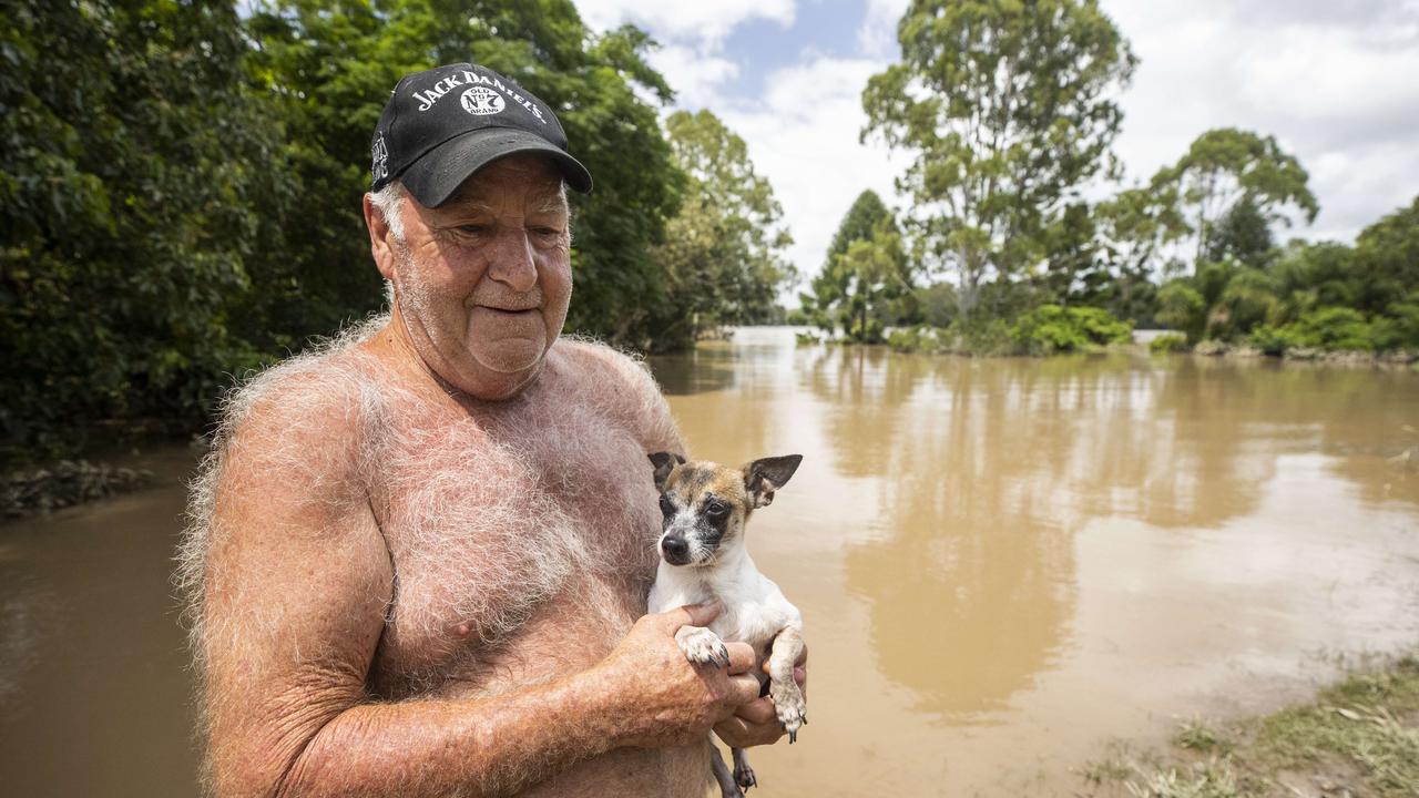 Greg Sears, with his dog Tadpole, says his home remains underwater. Picture: Lachie Millard