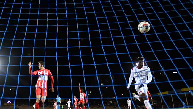 Adelaide United’s Al-Hassan Toure (right) scores his second goal in a 3-2 FFA Cup win over Brisbane’s Olympic at Perry Park in Brisbane. Picture: AAP Image/Darren England