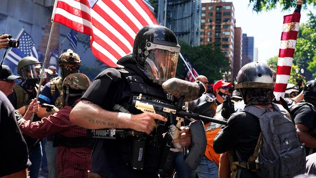 A member of the Proud Boys fires a paint ball gun into a crowd of anti-police protesters on August 22 in Portland, Oregon. Picture: Nathan Howard/Getty Images/AFP