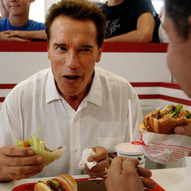 Arnold Schwarzenegger eats a hamburger wrapped in lettuce during a lunch break at an In-N-Out restaurant in California. Picture: Stephen Savoia/APSource:AAP