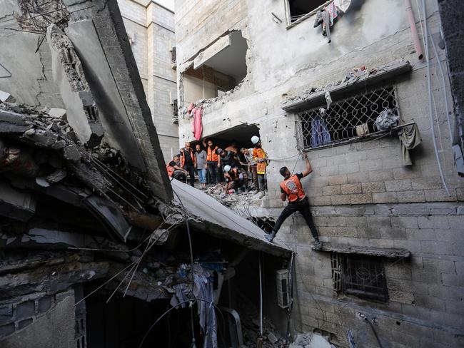 People search through buildings that were destroyed during Israeli air raids in the southern Gaza Strip. Picture: Ahmad Hasaballah/Getty Images