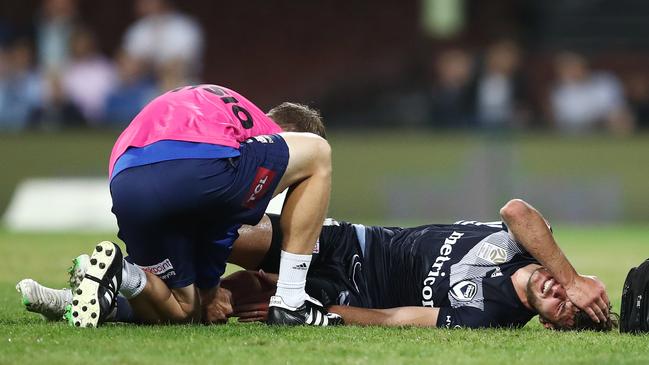 Terry Antonis of the Victory receives attention after injuring his knee playing against Sydney FC at the SCG. Picture: AAP Image/Brendon Thorne