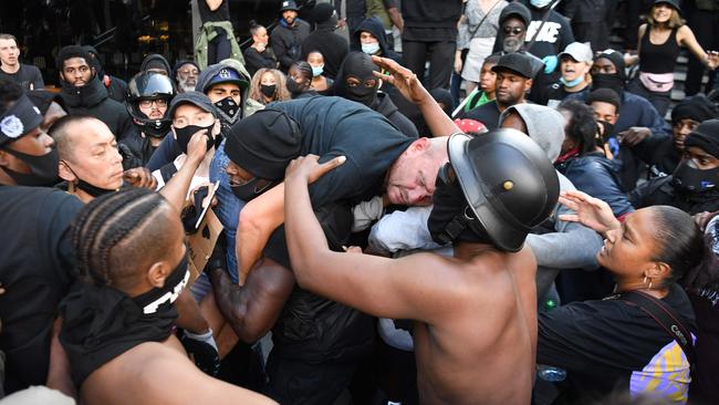 A man is lifted to safety during clashes between protesters supporting the Black Lives Matter movement and opponents in London. Picture: AFP