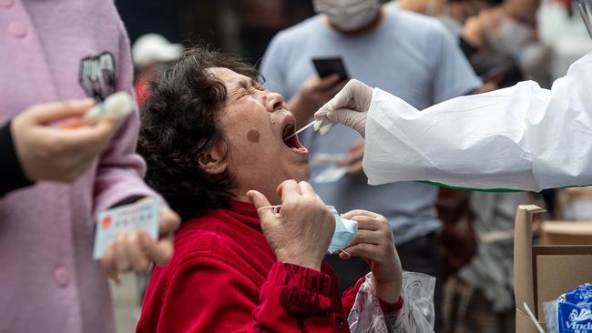 A medical worker takes a swab in a street of Wuhan at the weekend. Picture: AFP