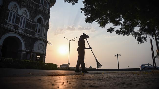 A worker sweeps another empty Mumbai street. Picture: Fariha Farooqui/Getty Images.