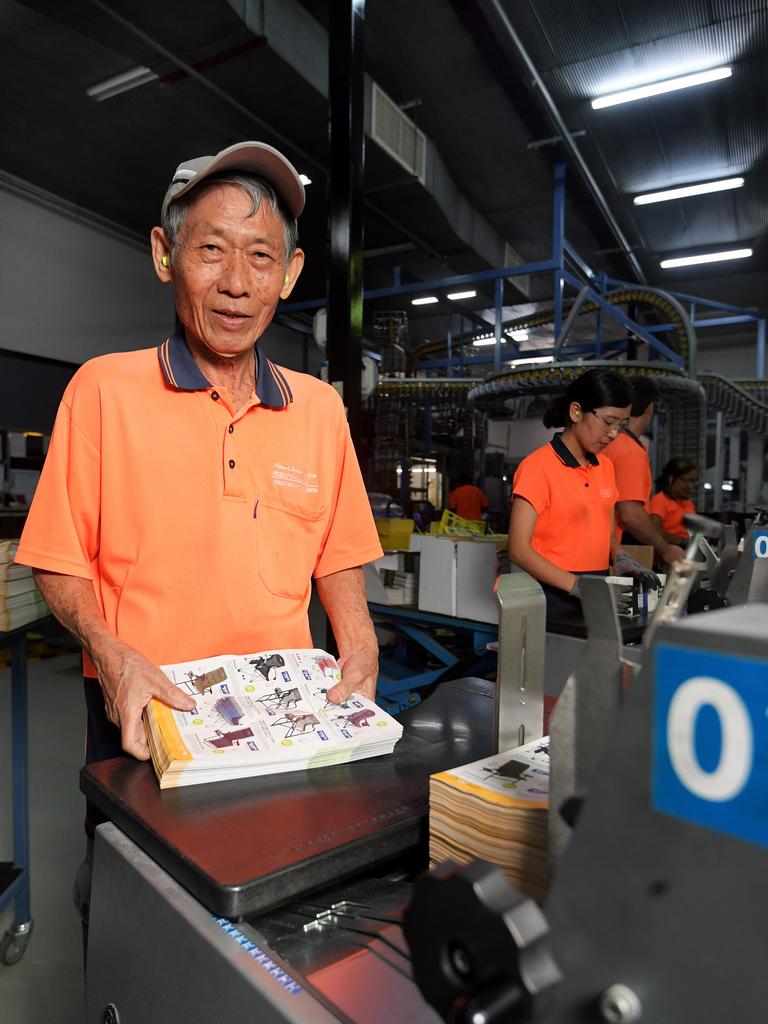 NT News inserter Thang Bian is seen inserting catalogues into the paper during the printing process. Pictures: KERI MEGELUS