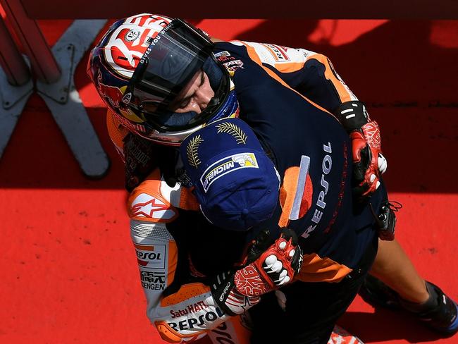 Dani Pedrosa is congratulated by a teammate after taking pole position.