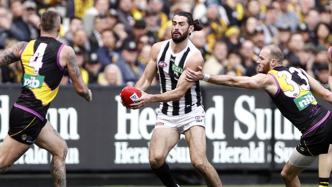 Brodie Grundy weaves through traffic.