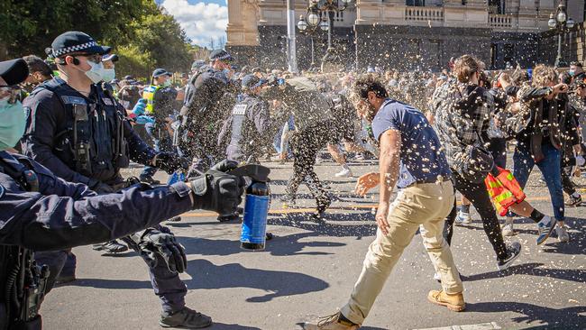 Protesters are showered in pepper spray during Saturday’s wild demonstrations. Picture: Jason Edwards