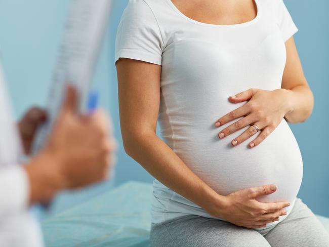 Pregnant woman with hands on stomach talking to obstetrician Picture: Istock
