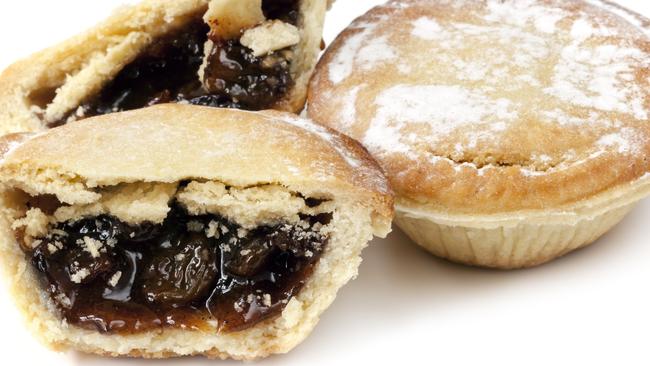 Two mince pies, isolated on white background.  One whole and the other cut.  Traditional Christmas fare.