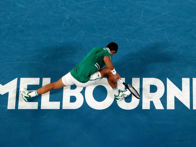 Novak Djokovic falls on the court in an attempt to hit a return against Taylor Fritz. Picture: AFP