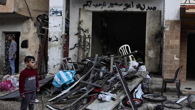 A Palestinian child stands next to a damaged building after Israeli forces raided the West Bank which is occupied by Israel. Picture: AFP