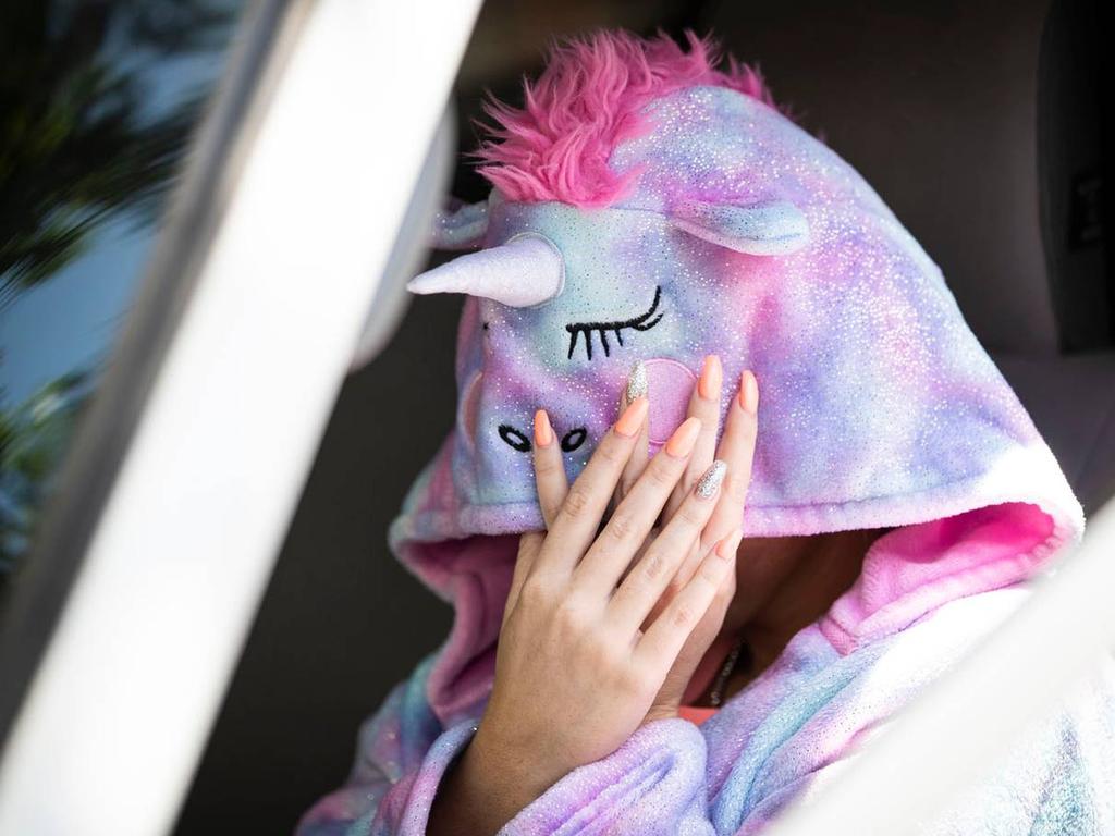 One of the tourists hides her face as she leaves the family’s accommodation in Auckland. Picture: Jason Oxenham/NZ Herald