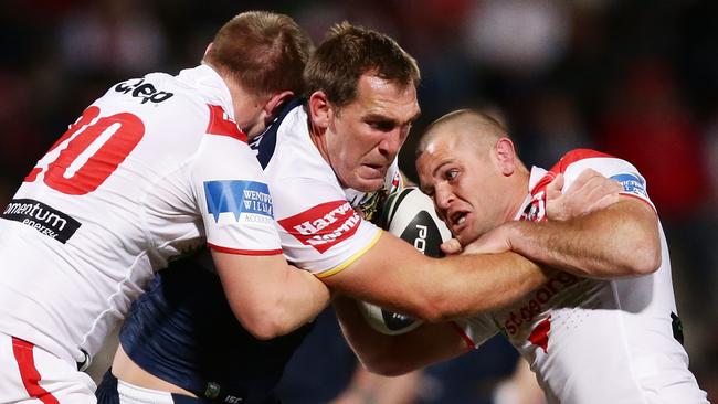 Scott Bolton is tackled by the Dragons defence.