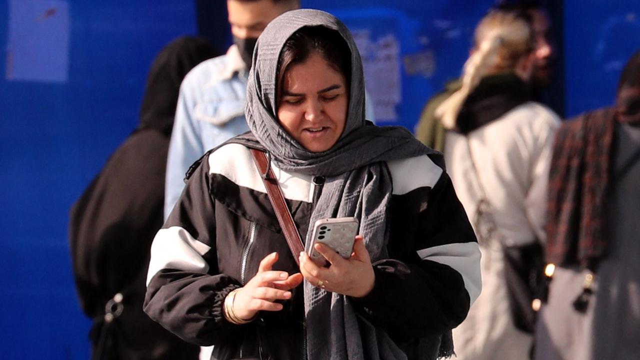 An Iranian woman checks her phone in a street in Tehran on January 18, 2024. Pakistan launched deadly strikes on January 18 against militant targets in Iran in apparent retaliation for Iranian air raids on its territory, further stoking tensions and prompting Tehran to summon Pakistan's envoy. Picture: AFP