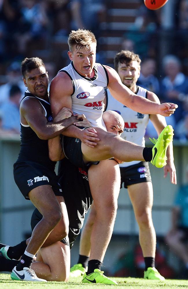 Ollie Wines gets his kick away under pressure from Jake Neade.