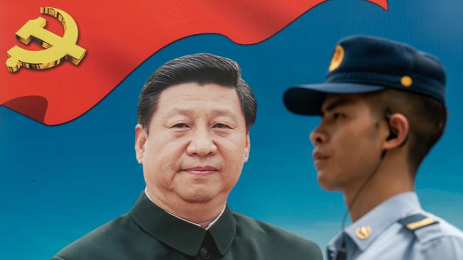 A member of the People's Liberation Army stands guard in front of a billboard of Chinese President Xi Jinping. Picture: Getty Images