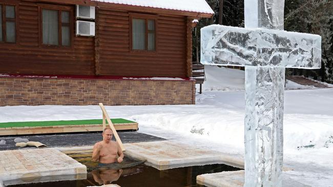 President Vladimir Putin crosses himself as he plunges into the icy waters during the celebration of the Epiphany holiday in Moscow. Picture: AFP