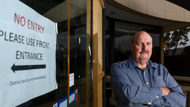 John Dellar with the boarded up area next to the sliding door that was smashed by burglars. 