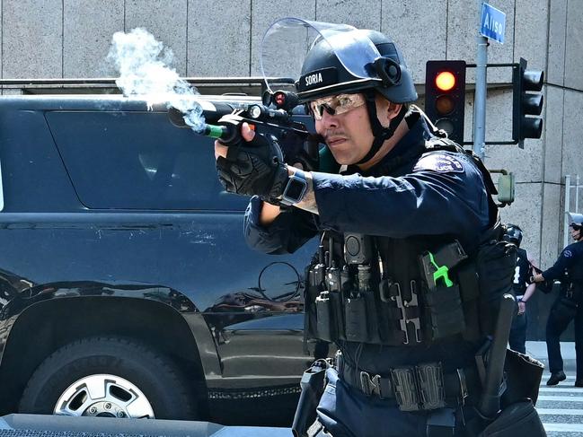 An officer shoots a flash-bang grenade outside the Metropolitan Detention Center, MDC, in downtown Los Angeles, California. Picture: AFP