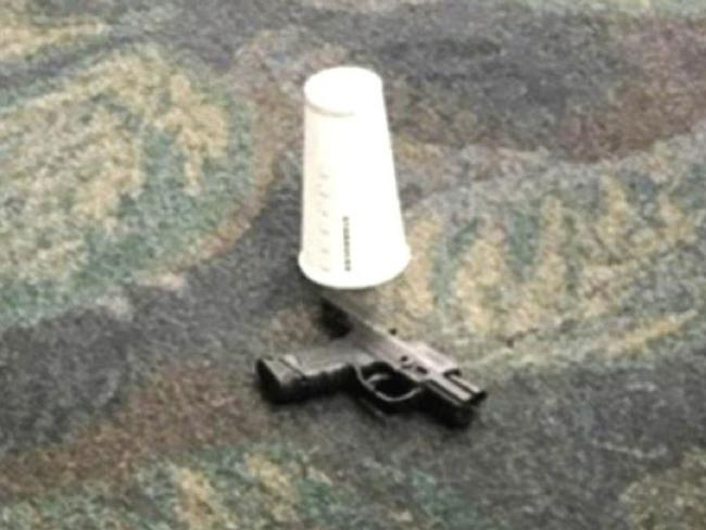 Passenger Mark Lea took this image of a hand gun allegedly used by Iraq war veteran Esteban Santiago when he killed five people at Fort Lauderdale airport. Picture: Mark Lea via AP