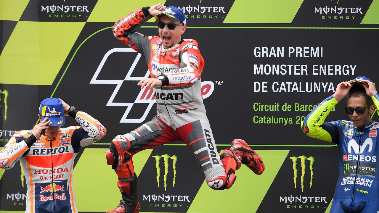 Jorge Lorenzo celebrates on the podium next to Marc Marquez and Valentino Rossi.