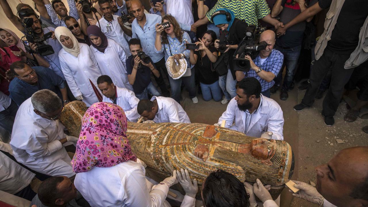 Employees of Egypt's Ministry of Antiquities open a sarcophagus.