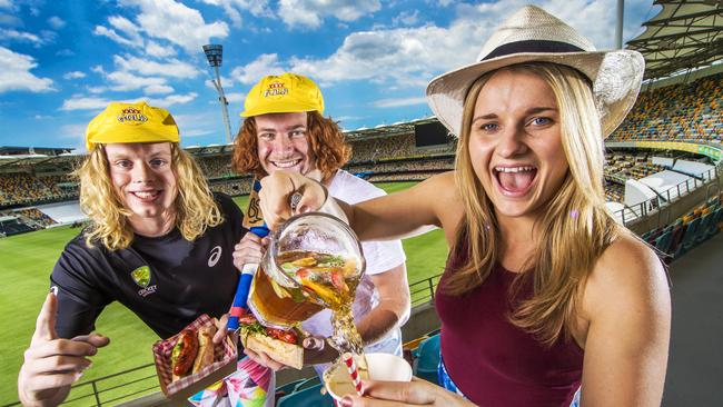 Alex Laube, 19, Oskar Baker, 19, and Danielle Sidney, 25, share a Pimm’s toast at the famous Brisbane cricket ground. Picture: Nigel Hallett.