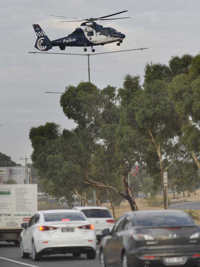 A police helicopter arrives at the scene. Picture: Tony Gough