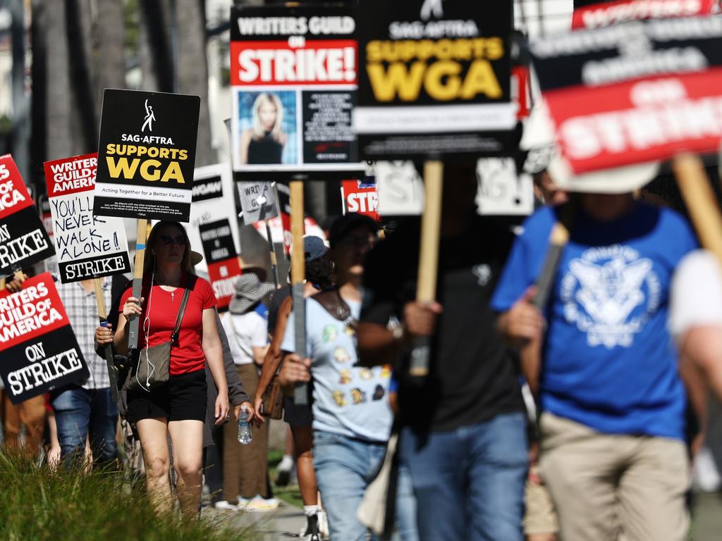 LOS ANGELES, CALIFORNIA - JULY 13: A sign reads 'SAG-AFTRA Supports WGA' as SAG-AFTRA members walk the picket line in solidarity with striking WGA (Writers Guild of America) workers outside Netflix offices on July 13, 2023 in Los Angeles, California. Members of SAG-AFTRA, HollywoodÃ¢â¬â¢s largest union which represents actors and other media professionals, will likely go on strike after a midnight deadline over contract negotiations with studios expired. The strike could shut down Hollywood productions completely with writers in the third month of their strike against Hollywood studios. (Photo by Mario Tama/Getty Images)