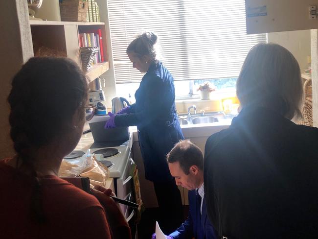 AFP officer rifling through Annika Smethurst's kitchen. Picture: Supplied