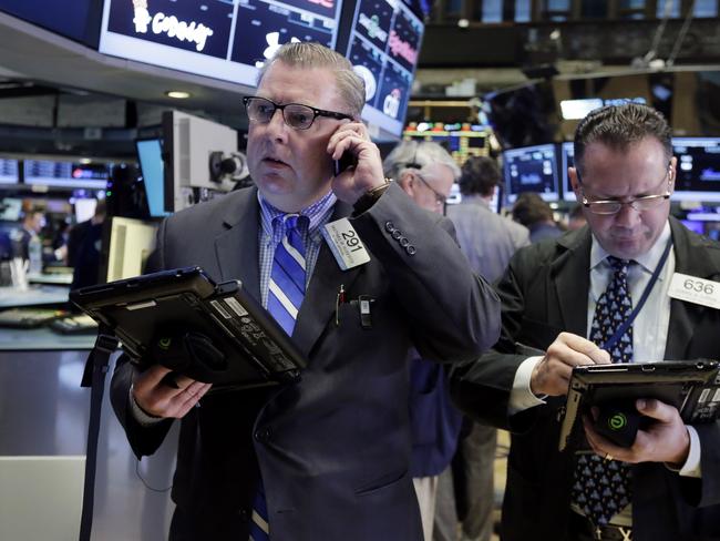 Traders Mathias Roberts, left, and Edward Curran work on the floor of the New York Stock Exchange, Tuesday, Nov. 10, 2015. Stocks are inching lower in early trading Tuesday, extending a slump that has brought the market lower for the past four trading days. (AP Photo/Richard Drew)