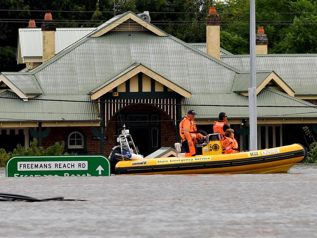 Rescue volunteers patrol around the flooded houses next to the old Windsor Bridge along the overflowing Hawkesbury river in Windsor in March. Picture: AFP