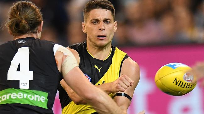 Dion Prestia fires off a handball under pressure from Bryce Gibbs.