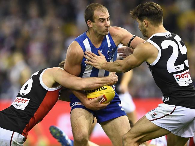 Ben Cunnington of the Kangaroos is tackled by Jack Newnes and Koby Stevens of the Saints.