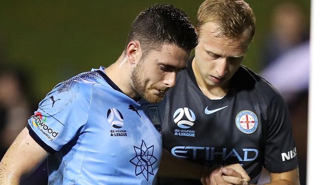 Sydney FC defender Ben Warland is helped from the field by Melbourne City’s Ritchie De Laet on Sunday. Picture: Getty Images 