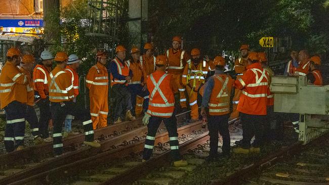 Rail workers surveying the train that hit powerlines near Homebush station on Tuesday. Picture: Thomas Lisson