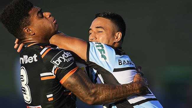 Valentine Holmes of the Sharks is tackled by Kevin Naiqama.
