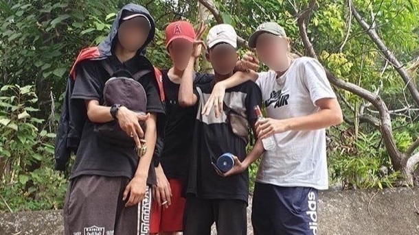 Teens pose up with liquor bottles at the island. Picture: Supplied