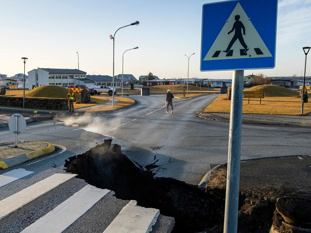 TOPSHOT - This photo taken on November 13, 2023 shows a crack cutting across the main road in Grindavik, southwestern Iceland following earthquakes. The southwestern town of Grindavik -- home to around 4,000 people -- was evacuated in the early hours of November 11 after magma shifting under the Earth's crust caused hundreds of earthquakes in what experts warned could be a precursor to a volcanic eruption.  The seismic activity damaged roads and buildings in the town situated 40 kilometres (25 miles) southwest of the capital Reykjavik, an AFP journalist saw. (Photo by Kjartan TORBJOERNSSON / AFP) / Iceland OUT