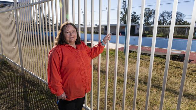 Local newsagent, Gayle Porter, at the fence of the now closed and drained 50 metre swimming pool in Tara. Picture: Mark Cranitch.