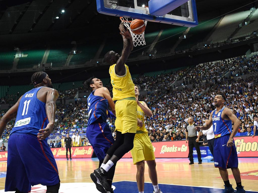 Australia's Thon maker (C, yellow) slums a dunk against June Fajardo (L) of the Philippines during their FIBA World Cup Asian qualifier game at the Philippine arena in Bocaue town, Bulacan province, north of Manila on July 2, 2018. Australia won by default 89-53. / AFP PHOTO / TED ALJIBE