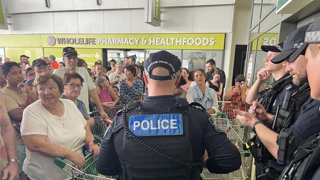 More than 200 Ingham residents wait for Woolworths to open on Wednesday with police letting 20 customers through at a time. Picture: Cameron Bates