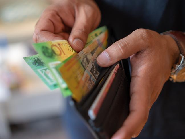 a male taking money out of a wallet, Australian cash generic spending