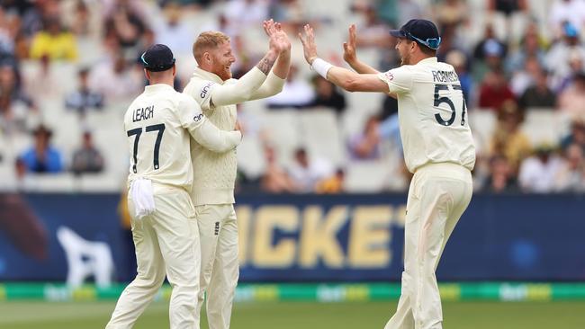 MELBOURNE, AUSTRALIA - DECEMBER 27: Ben Stokes (C) of England celebrates with teammates Jack Leach and Ollie Robinson after dismissing Alex Carey of Australia during day two of the Third Test match in the Ashes series between Australia and England at Melbourne Cricket Ground on December 27, 2021 in Melbourne, Australia. (Photo by Robert Cianflone/Getty Images)